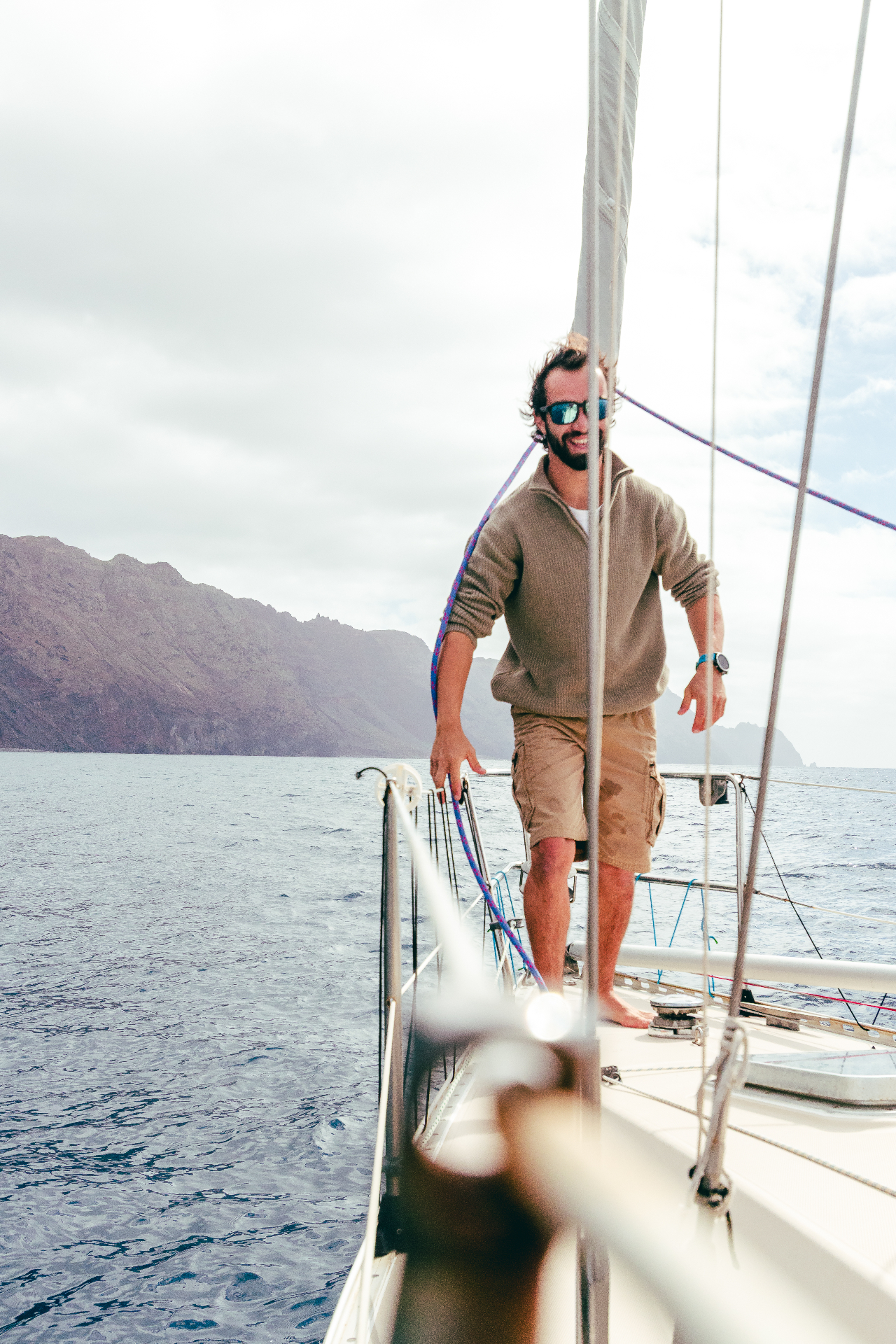 Alexandre at the bow as LAZER glides past sea cliffs